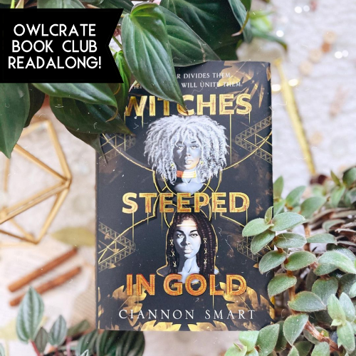 A copy of Witches Steeped in Gold laying in some green plants on a white background